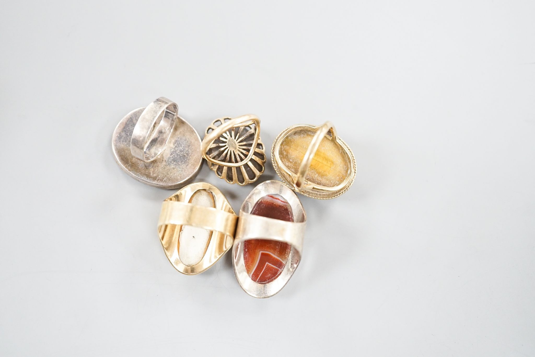 Three assorted 9ct gold and gem set dress rings, including blue john, smoky quartz and tiger's eye quartz, gross 23.9 grams and two white metal and hardstone set dress rings.